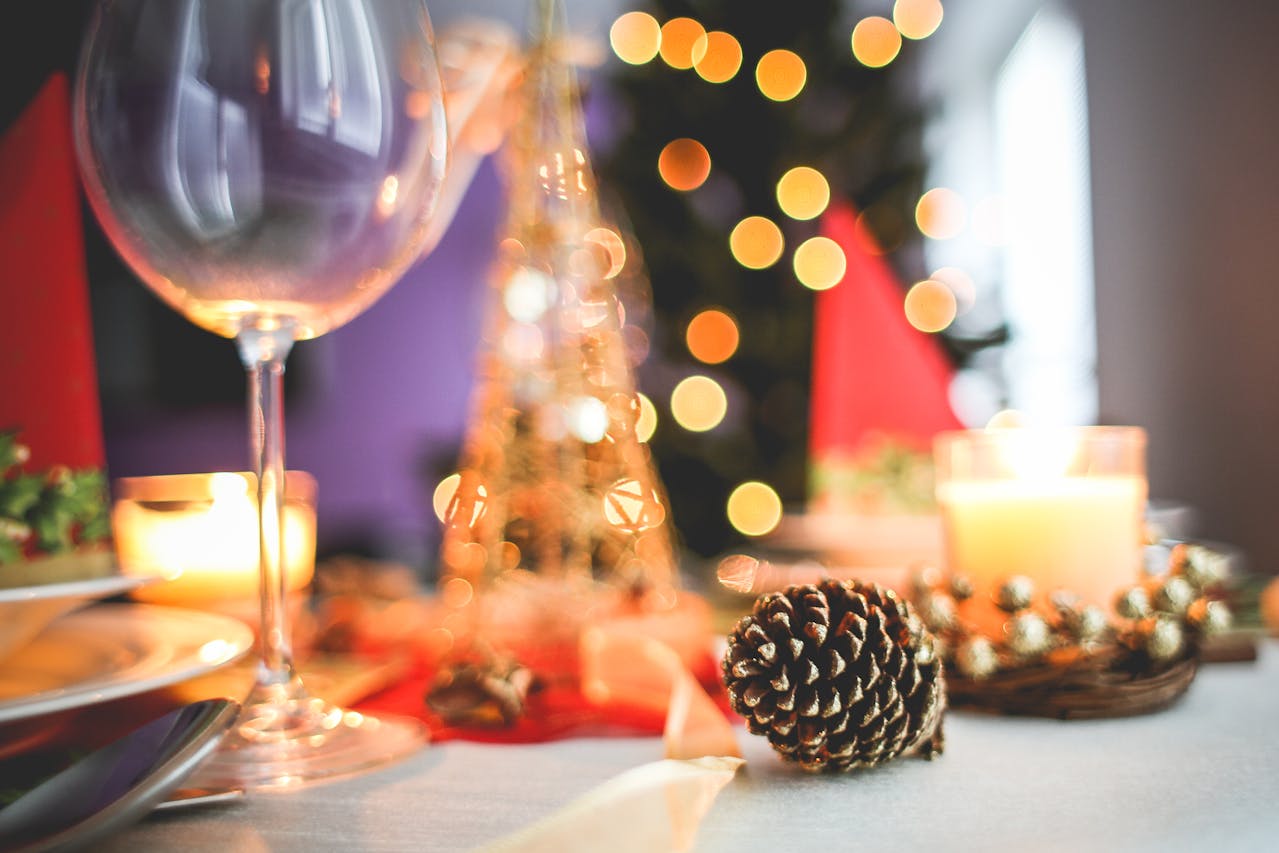 Brown acorn near clear long stem wine glass.